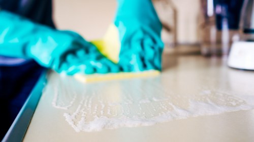 Cleaner wearing PPE while carrying out a safe cleaning task